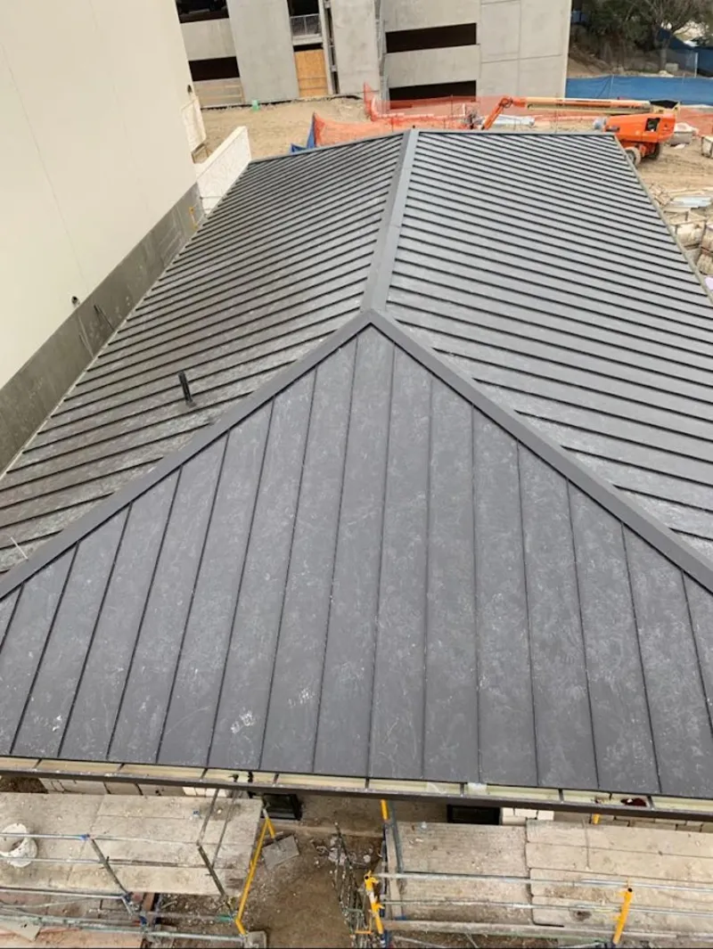 Commercial metal roof construction with crane equipment in Wyldwood